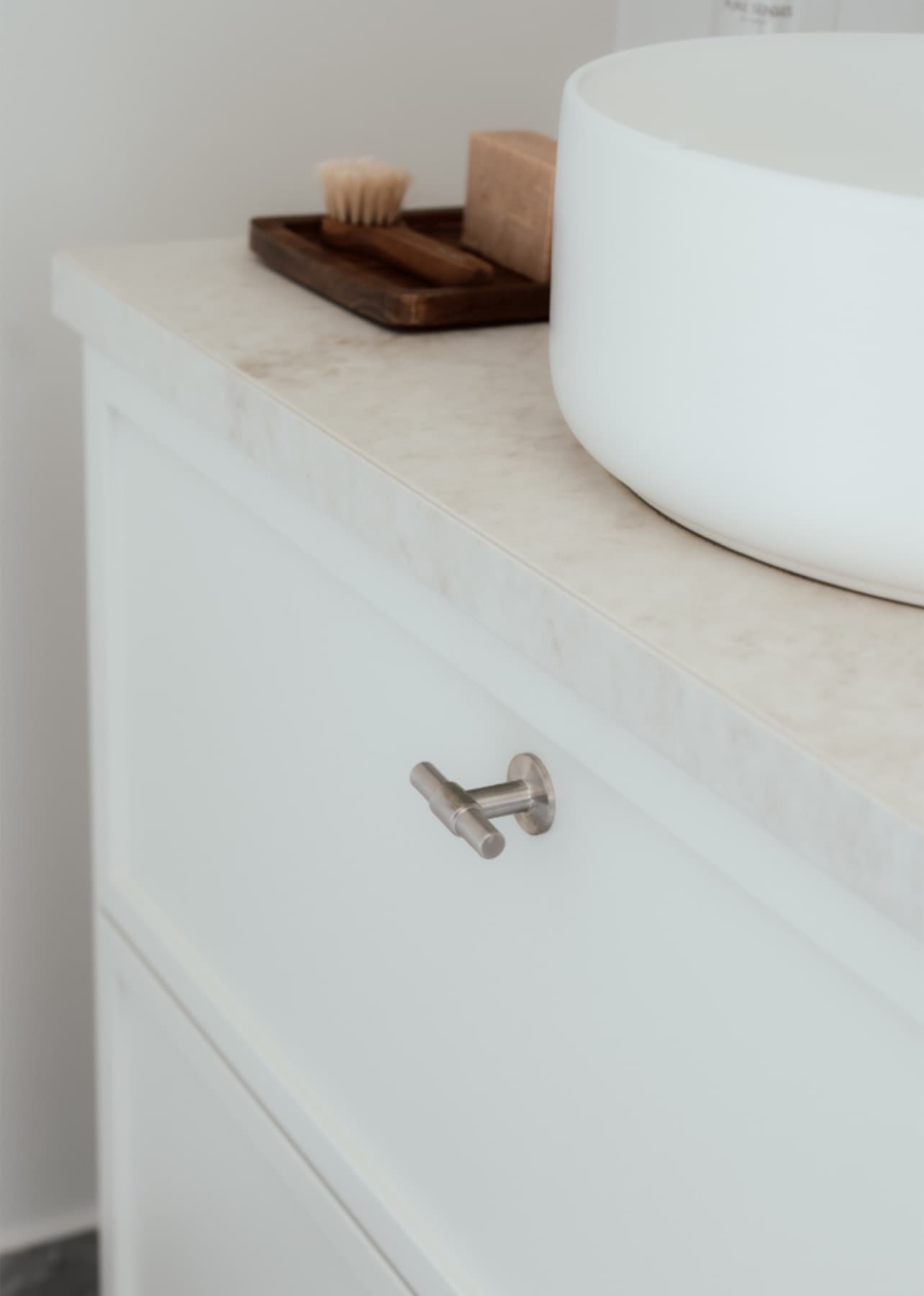 Detalj fra lyst baderom med natursteinspreg